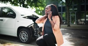 Mujer hispana lesionada hablando por teléfono tras un accidente de auto en Seattle, ejemplo de errores que no debes cometer después de un choque según abogado de accidentes en Washington